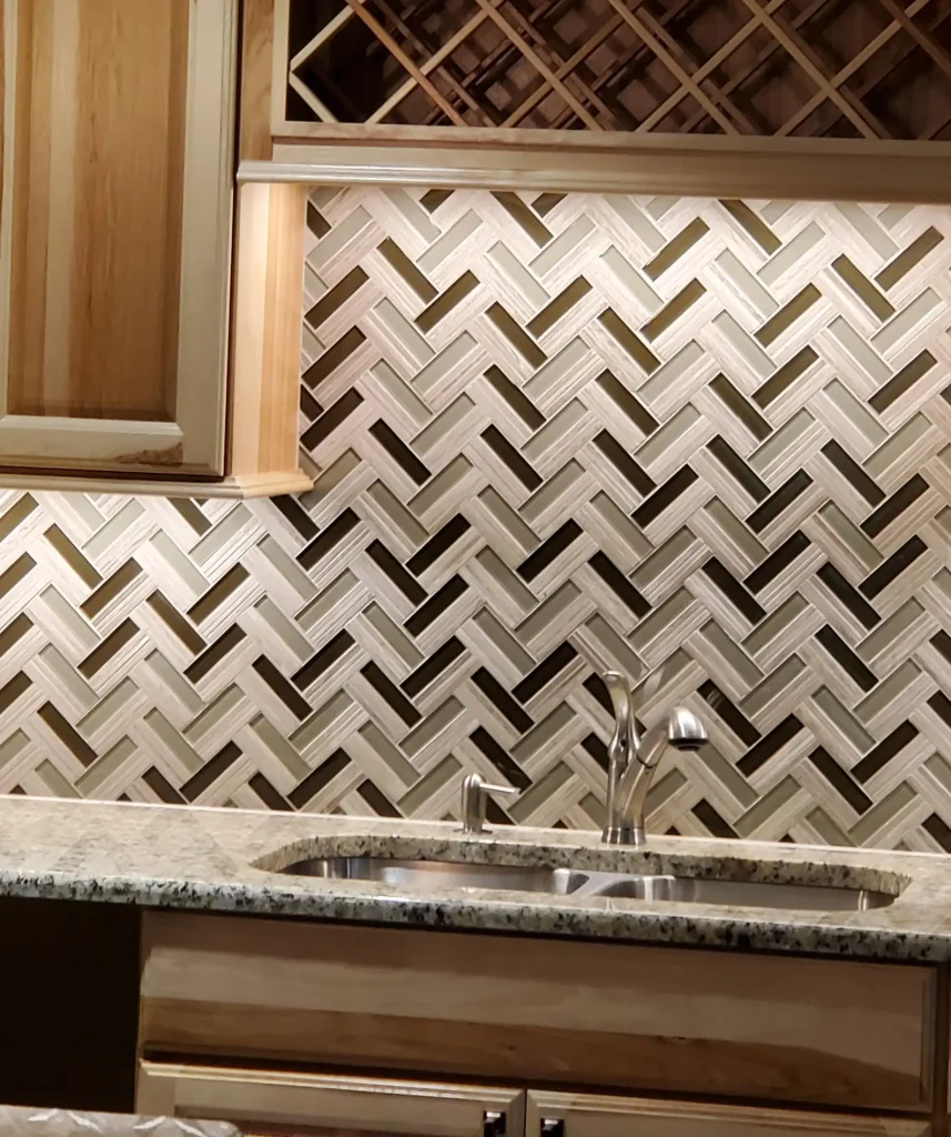 A kitchen with a herringbone tile backsplash.