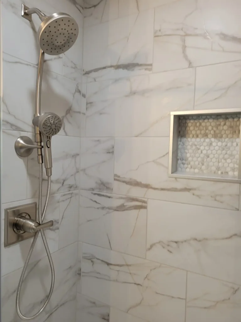 A marble shower with a shower head and shower head.