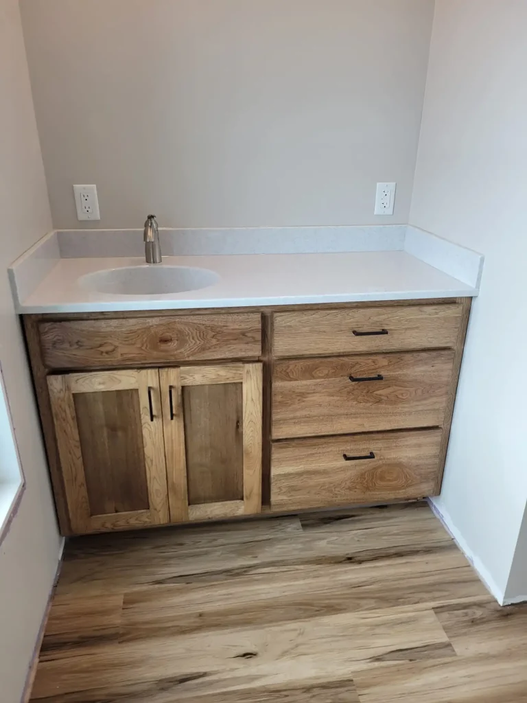 A bathroom with wooden cabinets and a sink.
