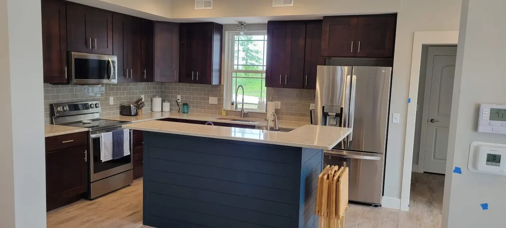 A kitchen with dark wood cabinets and stainless steel appliances.